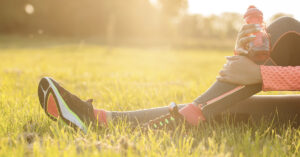 Runner in athletic wear sitting in the grass.