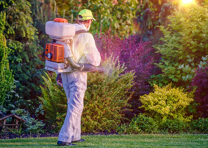 Pest control technician spraying for ticks
